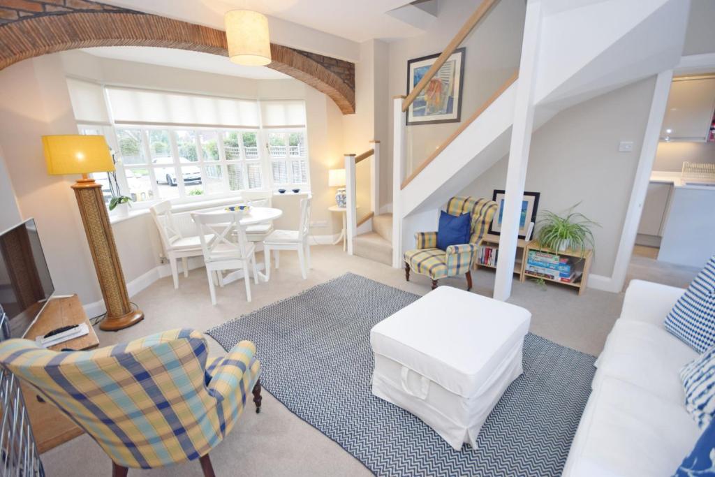 a living room with a couch and chairs and a table at Seagull Cottage, Aldwick in Bognor Regis