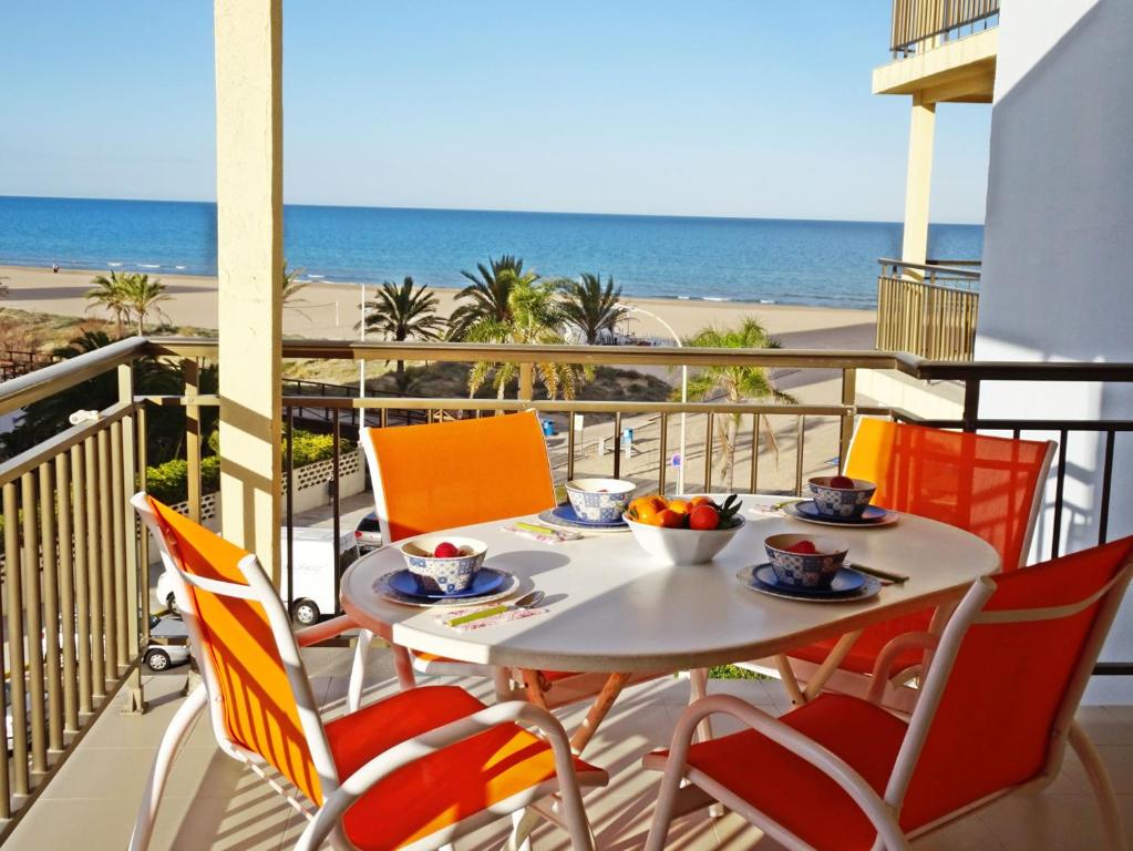 ein Tisch und Stühle auf einem Balkon mit Blick auf den Strand in der Unterkunft ALMIRANTE Vista al mar - Alquiler familias in Playa de Gandia
