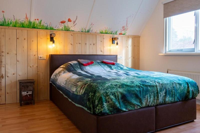 ein Schlafzimmer mit einem großen Bett in einem Zimmer in der Unterkunft Nieuw: Kom in de Bedstee Uniek! in Winterswijk