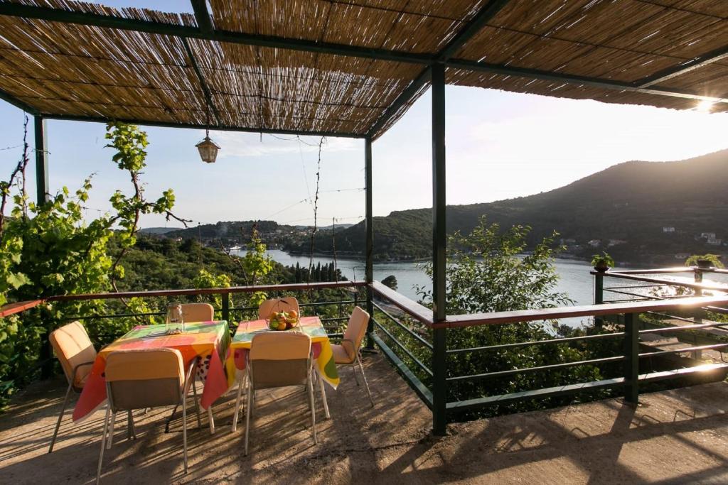 een tafel en stoelen op een balkon met uitzicht op een rivier bij Bodul Vacation Apartment in Zaton