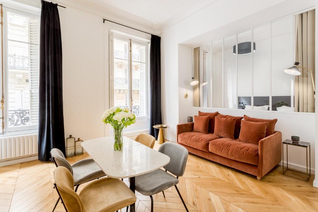 ein Wohnzimmer mit einem Sofa und einem Tisch in der Unterkunft Appartement Echelle in Paris