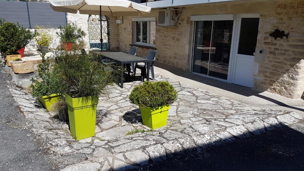 un patio con tres contenedores amarillos con plantas. en PERCHE, FISH AND GITES en Lanzac