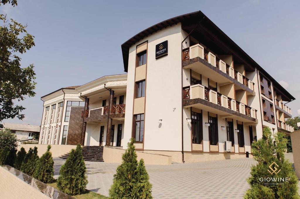 ein großes weißes Gebäude mit Bäumen davor in der Unterkunft Giowine Hotel & Restaurant in Cricova