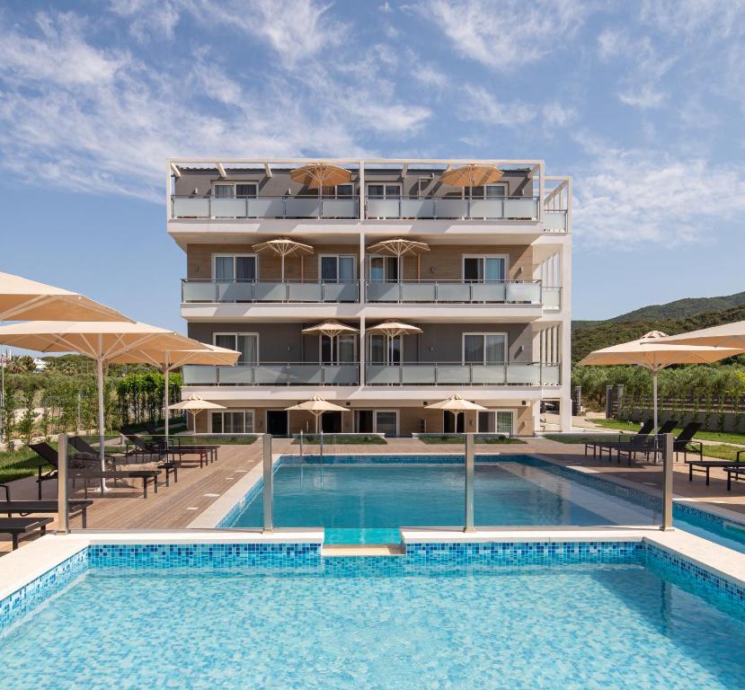 a hotel with a swimming pool in front of a building at Astra Sarti Luxury Suites in Sarti