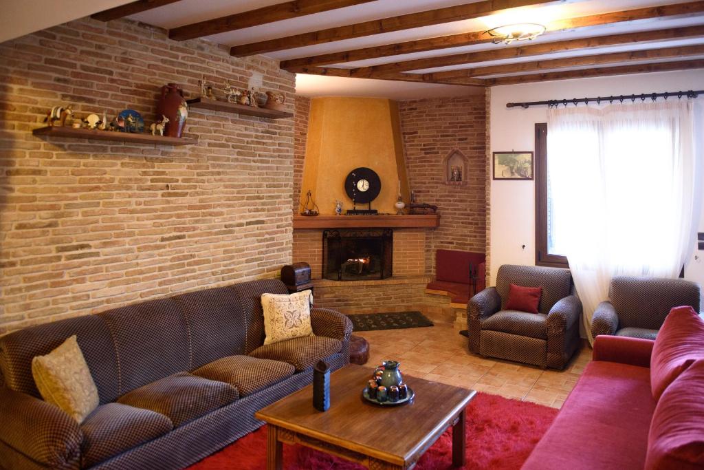 a living room with couches and a brick wall at Villa Mainalo - House near the Forest & Ski resort 