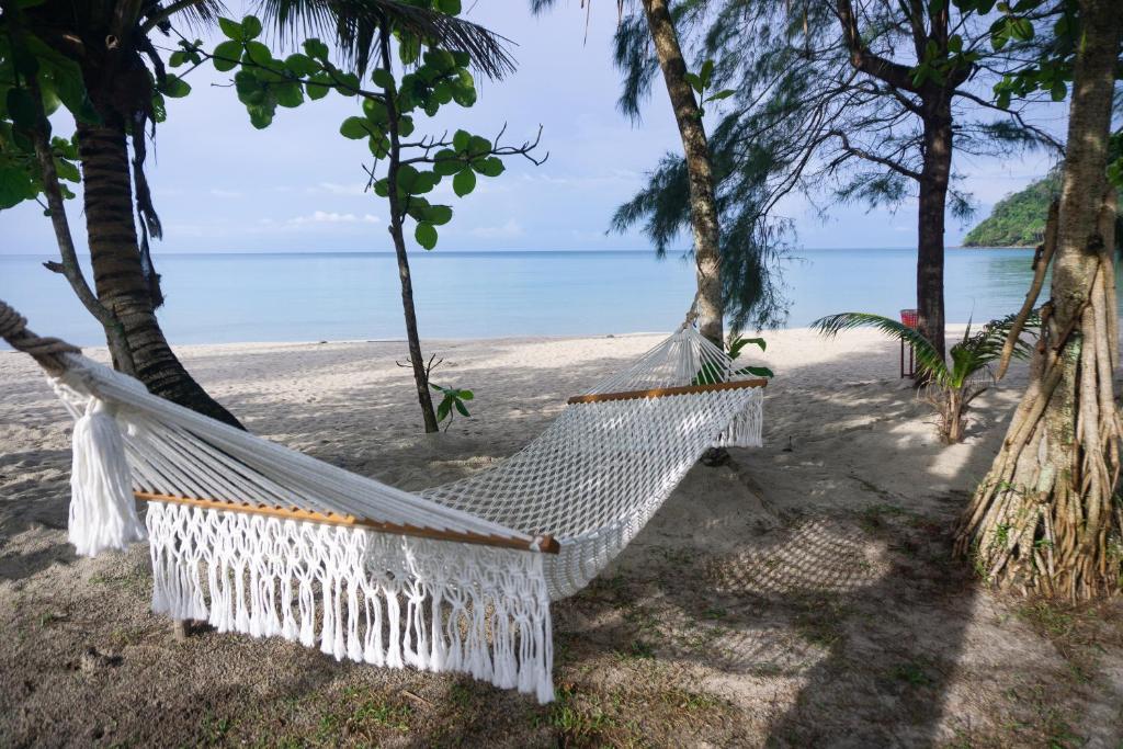 een hangmat op een strand met de oceaan op de achtergrond bij I-Lay House Koh Kood in Ko Kood