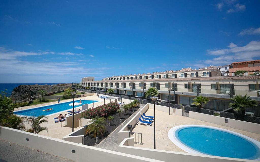 サンミゲル・デ・アボナにあるAmarilla Golfのスイミングプールと海を望むホテルの景色を望めます。