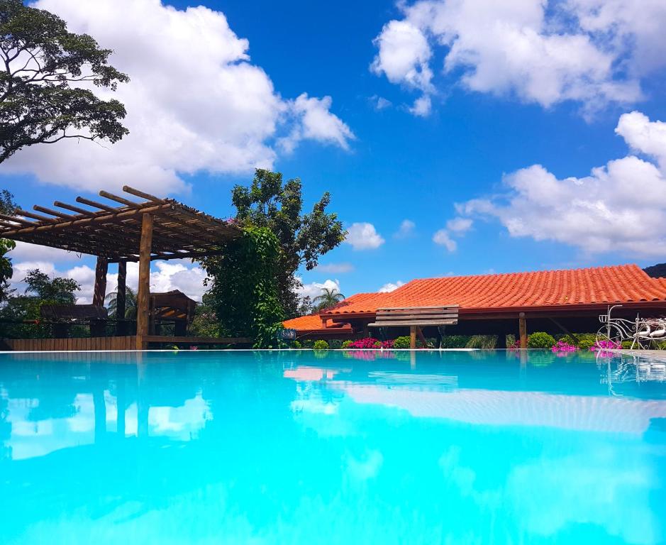 a swimming pool in front of a building with blue water at Pousada Kafundó - Inhotim in Brumadinho