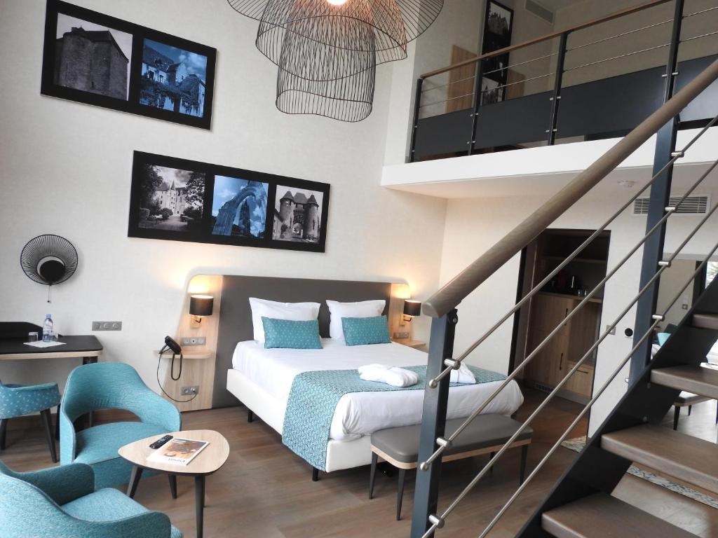 a bedroom with a bed and a staircase with blue chairs at Relais Saint Jacques - Châteauroux in Déols