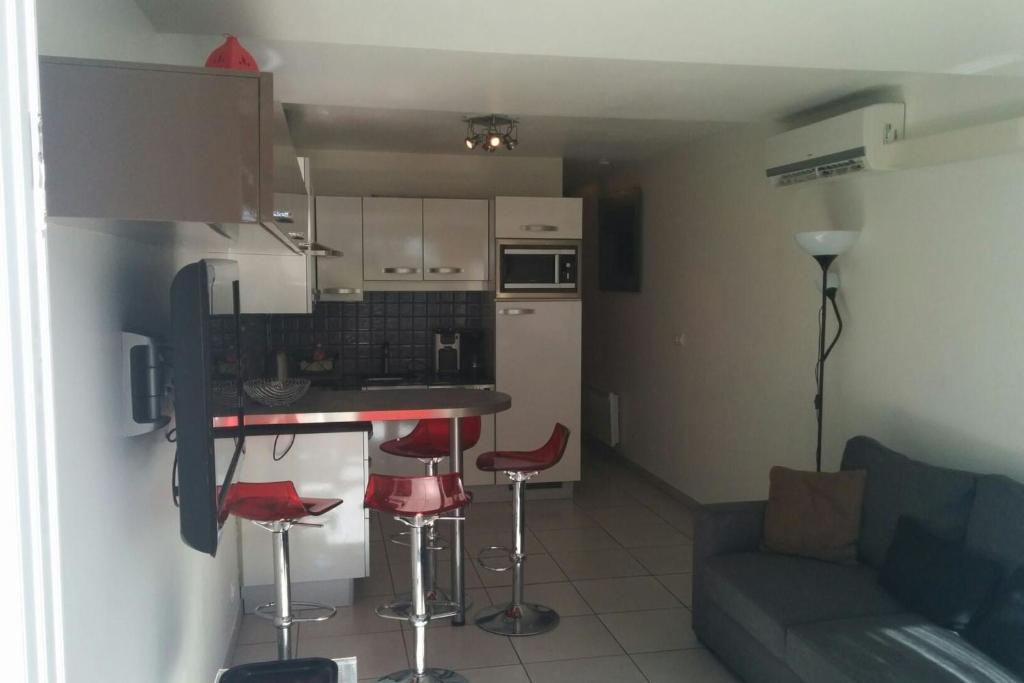 een keuken en een woonkamer met een bank en een tafel bij Cap d 'Agde Naturist Port Nature 8 in Cap d'Agde