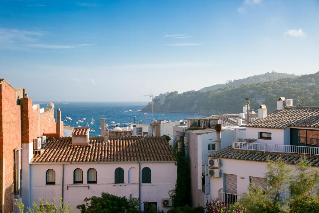 uitzicht op daken van huizen en de oceaan bij El Niu in Calella de Palafrugell