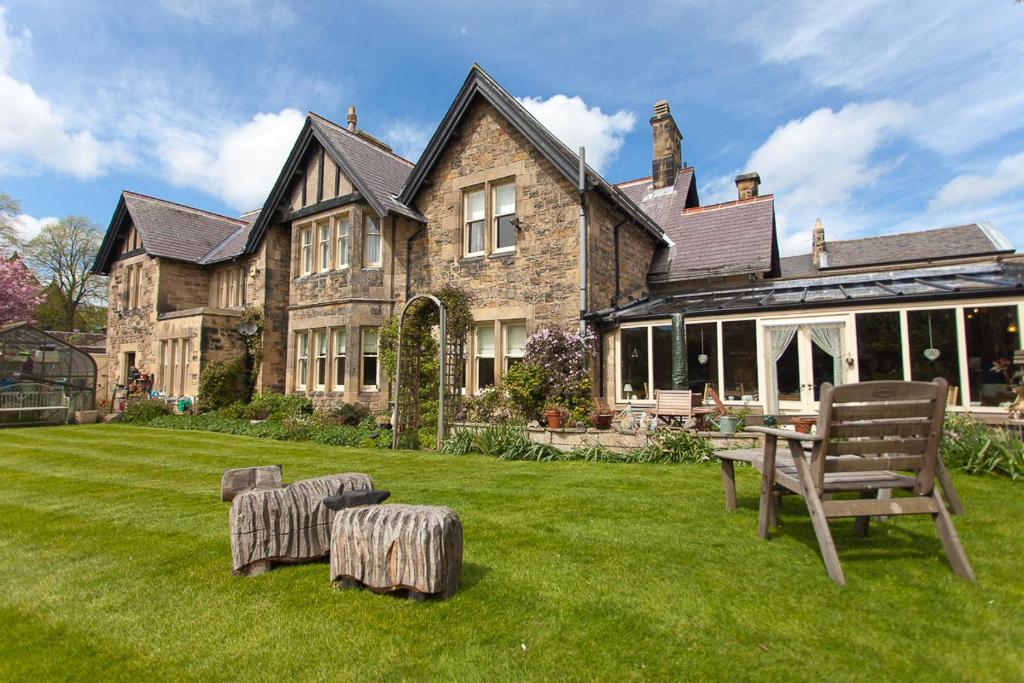 a house with a yard with a table and chairs at Greycroft B&B in Alnwick