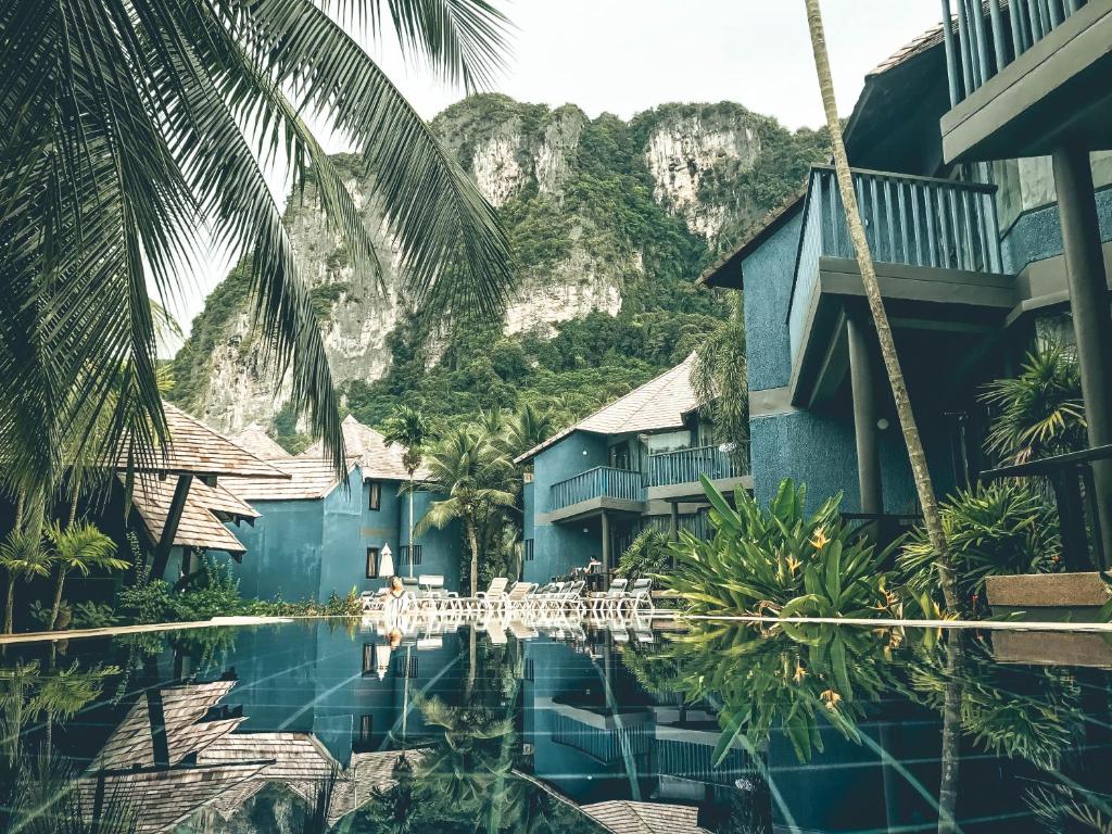 a resort with a pool in front of a mountain at Peace Laguna Resort & Spa - SHA Extra Plus in Ao Nang Beach