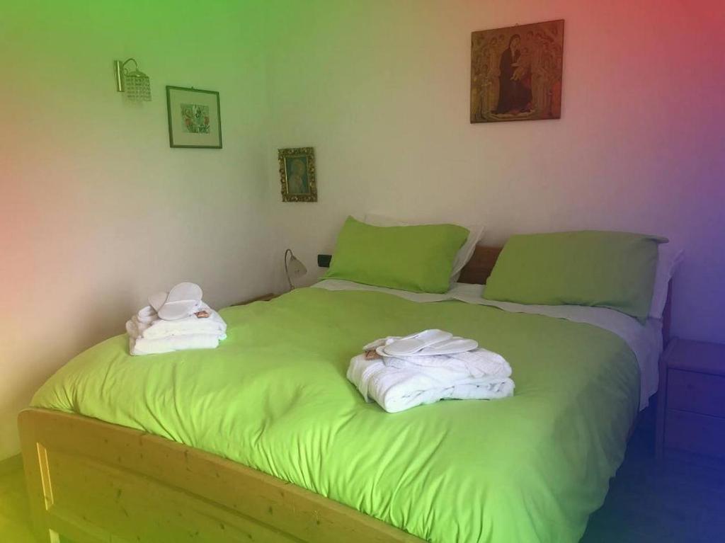 een groen bed met handdoeken erop bij A Casa di Rita in Coredo