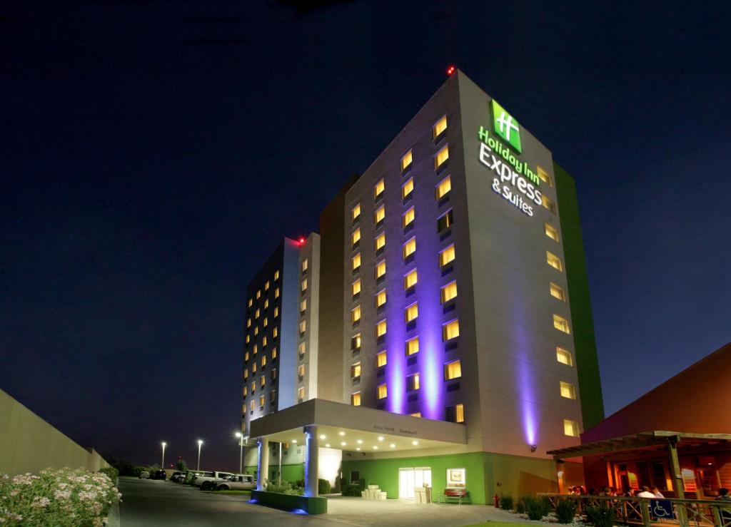 un hôtel avec un bâtiment éclairé la nuit dans l'établissement Holiday Inn Express & Suites Monterrey Aeropuerto, an IHG Hotel, à Monterrey