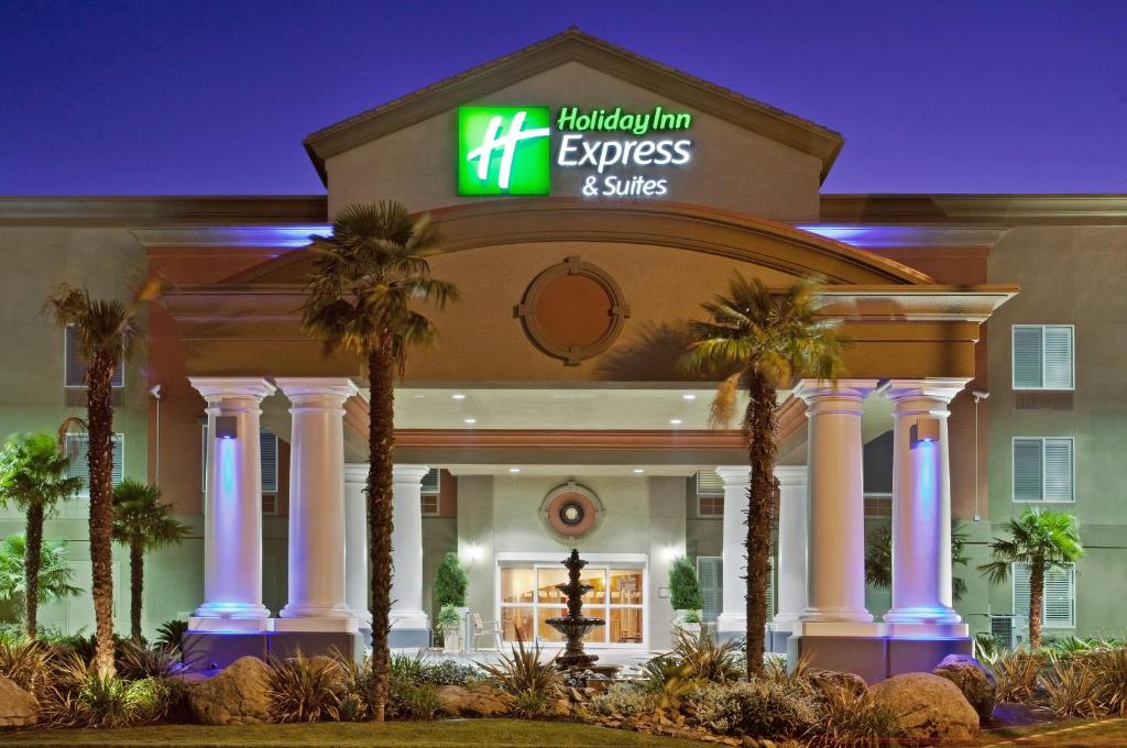 una locanda per l'accoglienza express e suite in un edificio con palme di Holiday Inn Express Hotel & Suites Modesto-Salida, an IHG Hotel a Modesto