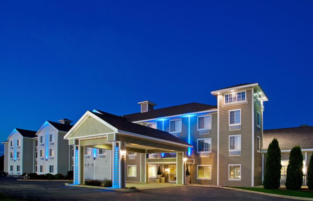 un gran edificio de apartamentos por la noche con luces azules en Holiday Inn Express & Suites New Buffalo, MI, an IHG Hotel, en New Buffalo