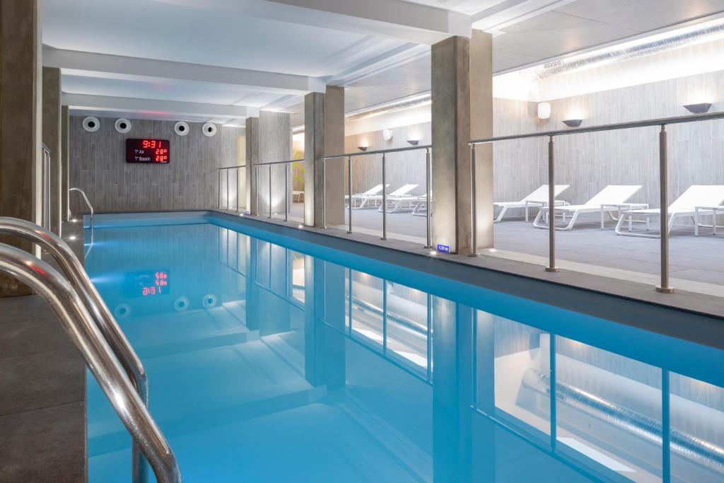 a swimming pool with a large blue tub in it at Terre de Provence Hôtel & Spa in Le Pontet