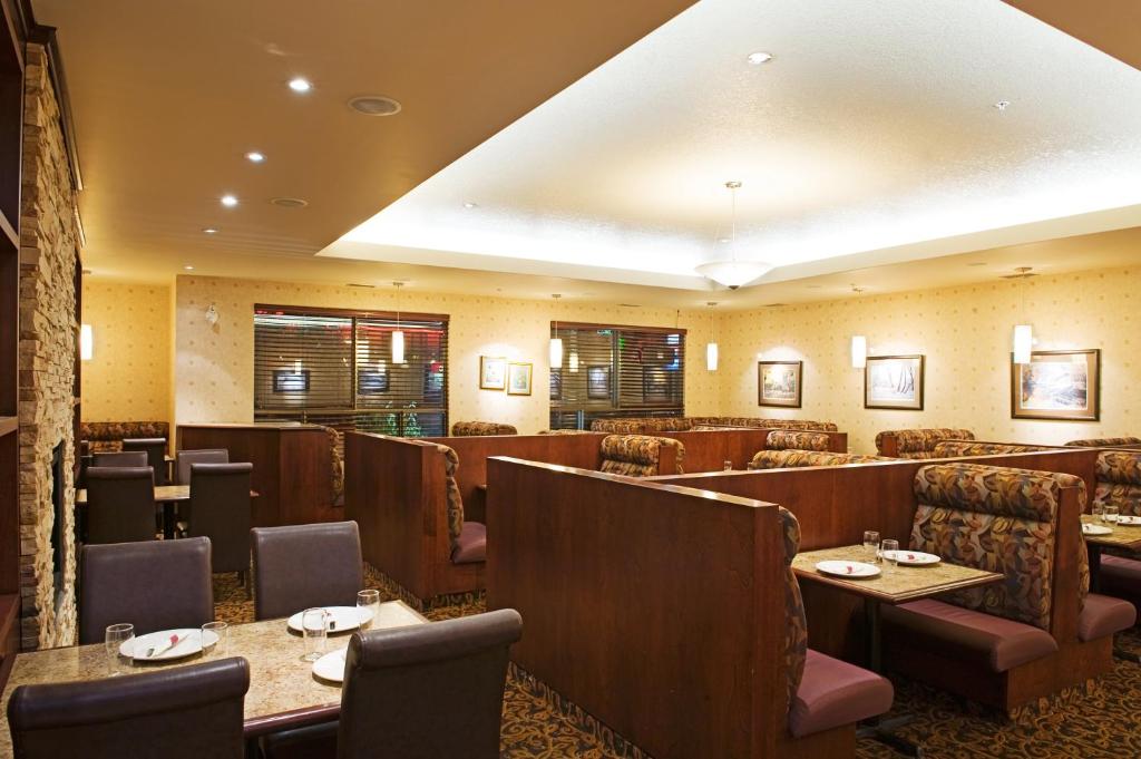 een restaurant met tafels en stoelen in een kamer bij Holiday Inn & Suites Lloydminster by IHG in Lloydminster