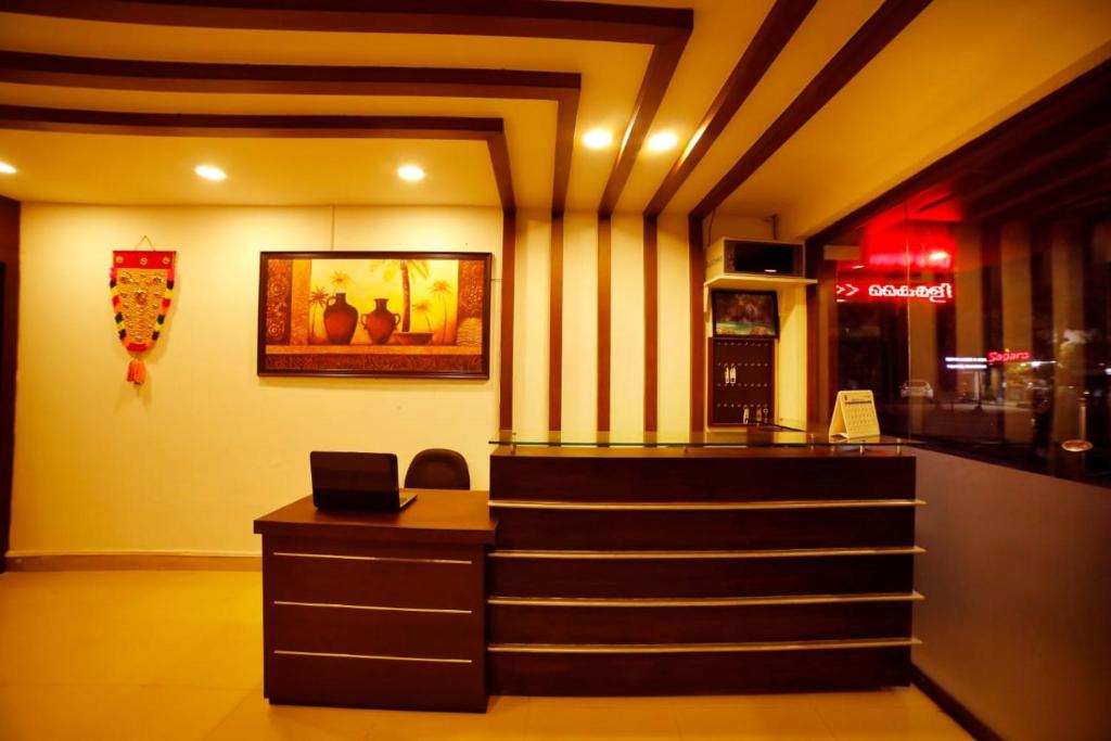 a restaurant with a counter and stairs in a room at Kairali Tourist Home in Guruvāyūr