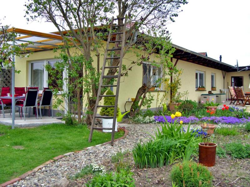 a garden with a ladder in front of a house at Ferienhaus Ursula in Malchow