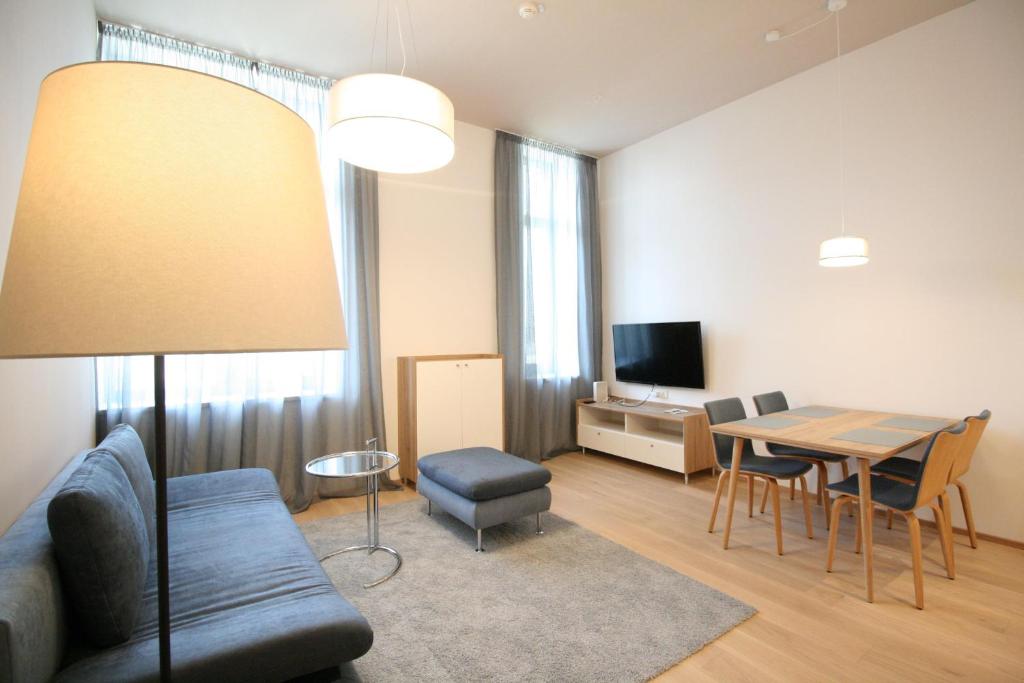 a living room with a couch and a table with chairs at Your Living Vienna CBD in Vienna