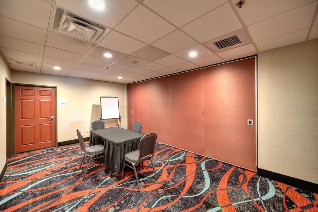 a conference room with a table and chairs on a rug at Holiday Inn Express Hotel & Suites Manteca by IHG in Manteca