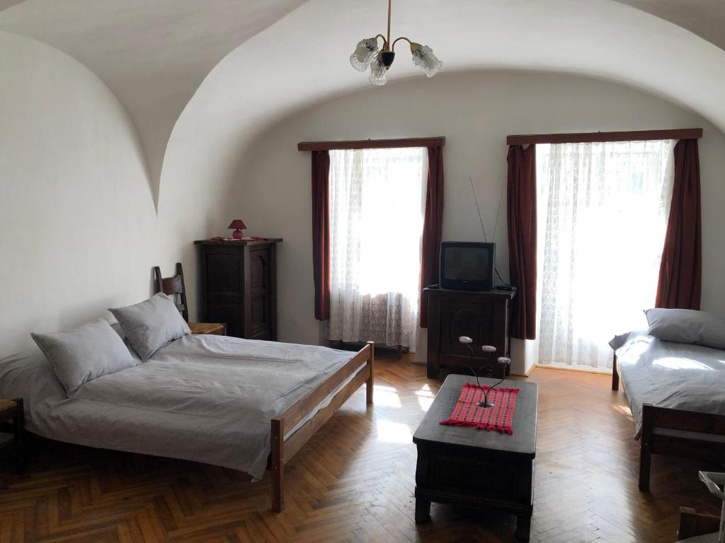 a bedroom with a bed and a couch and two windows at Apartman Bécsi utca in Sopron