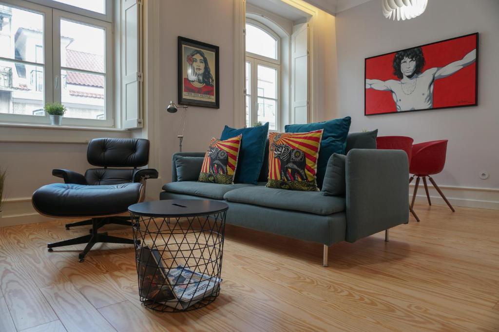 ein Wohnzimmer mit einem blauen Sofa und Stühlen in der Unterkunft Lisbon Center Rua Augusta Modern Art Apartment in Lissabon