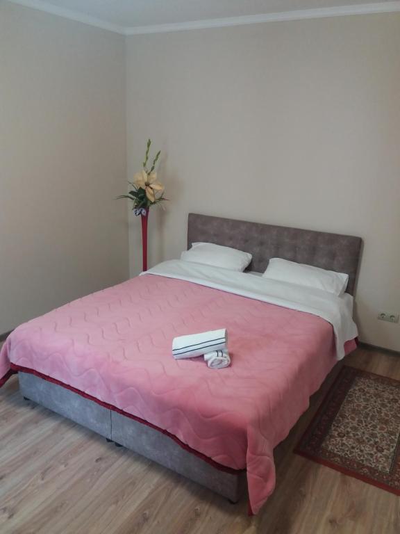 a bedroom with a pink bed with two books on it at ALIANCE апартамети в центрі міста. in Ivano-Frankivsk