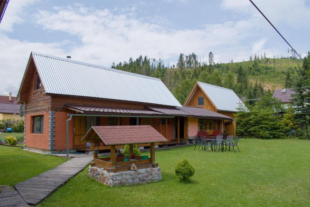 a log cabin with a table and chairs in a yard at CHATA JURAJ in Mlynky 