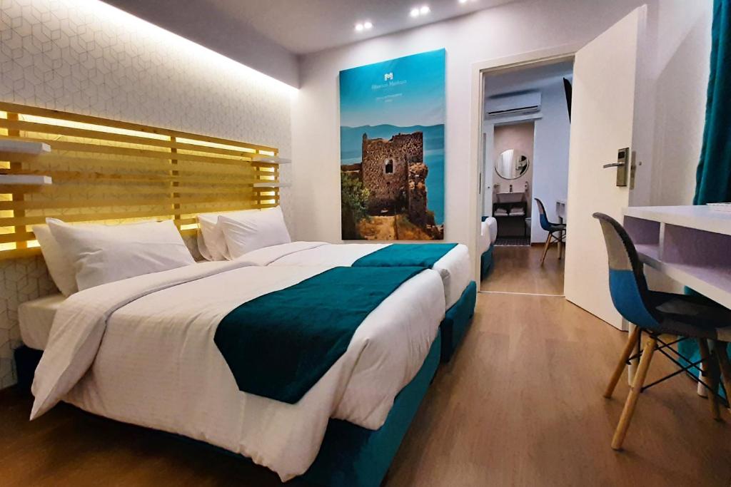 una camera d'albergo con un grande letto e un tavolo di Athenian Montaza Hotel ad Atene