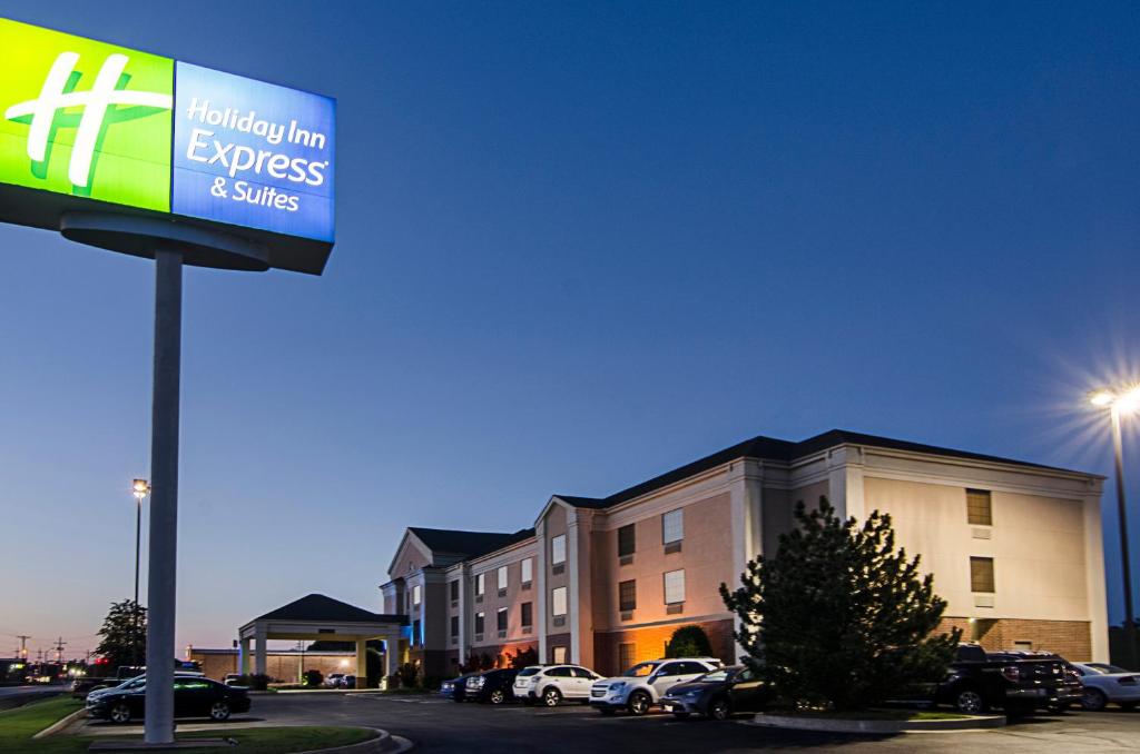 un cartello per un hotel con auto parcheggiate di fronte a un edificio di Holiday Inn Express Hotel & Suites Vinita, an IHG Hotel a Vinita