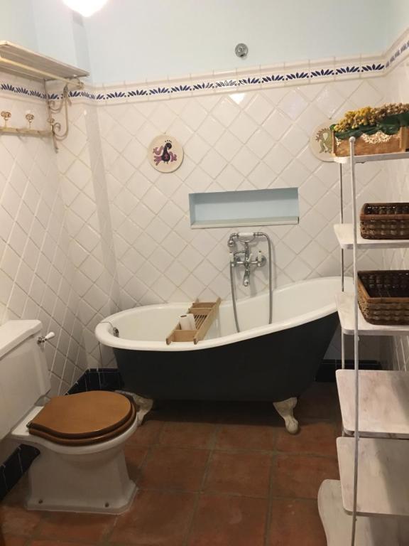 y baño con bañera, aseo y lavamanos. en La casita de la dormilona, en Algimia de Almonacid