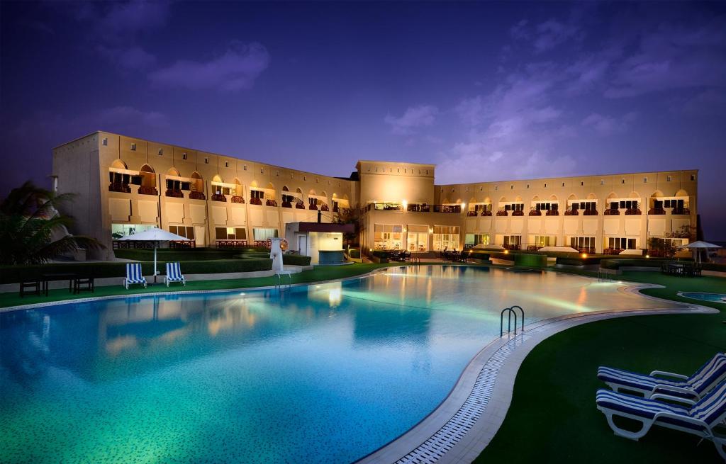 a large swimming pool in front of a building at Masira Island Resort in Ḩilf