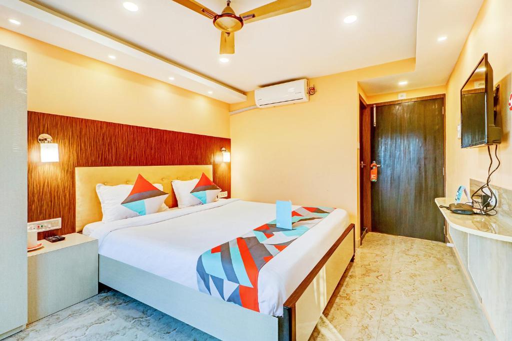 ein Hotelzimmer mit einem großen Bett und einem Waschbecken in der Unterkunft FabExpress Step Inn in Kalkutta