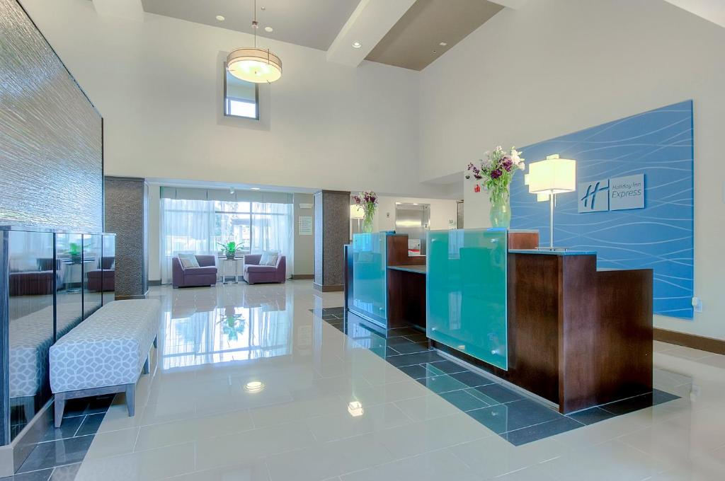 a lobby with a reception desk in a building at Holiday Inn Express & Suites Carlsbad Beach by IHG in Carlsbad