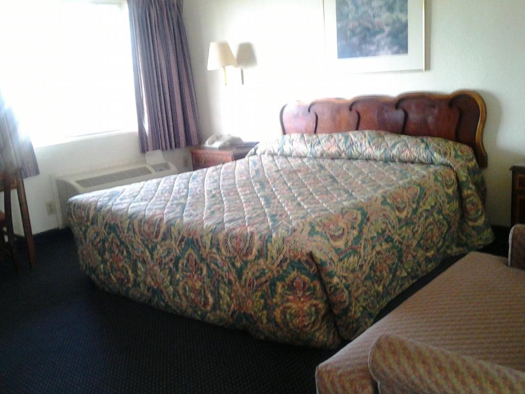 a hotel room with a bed in a room at Budget Inn in Tulare