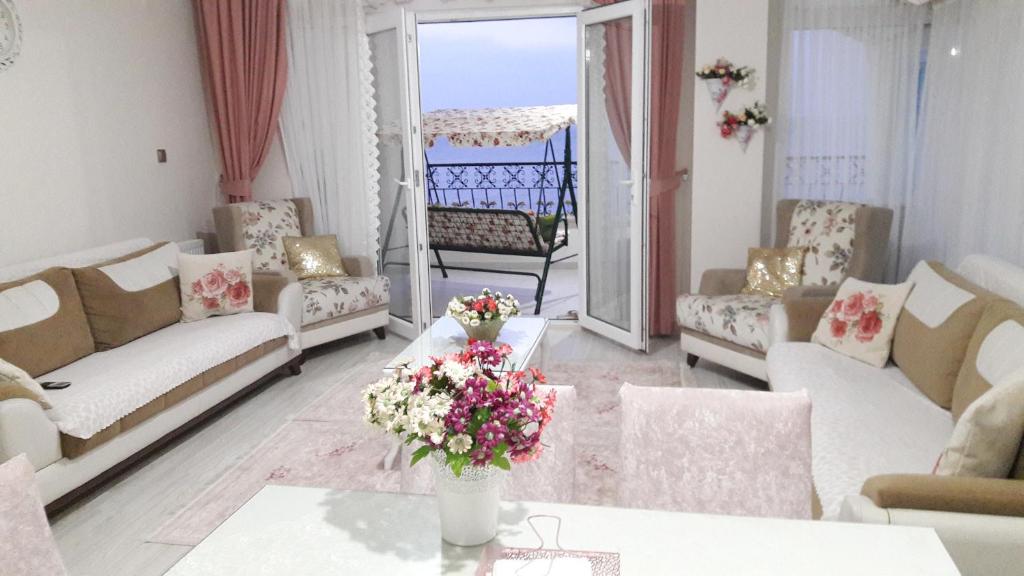 a living room with couches and a table with flowers at Trabzon Sea Palace in Trabzon