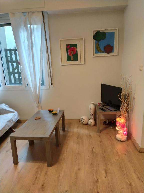 A television and/or entertainment centre at Cozy apartment ideally located city center and Megaron Moussikis metro station