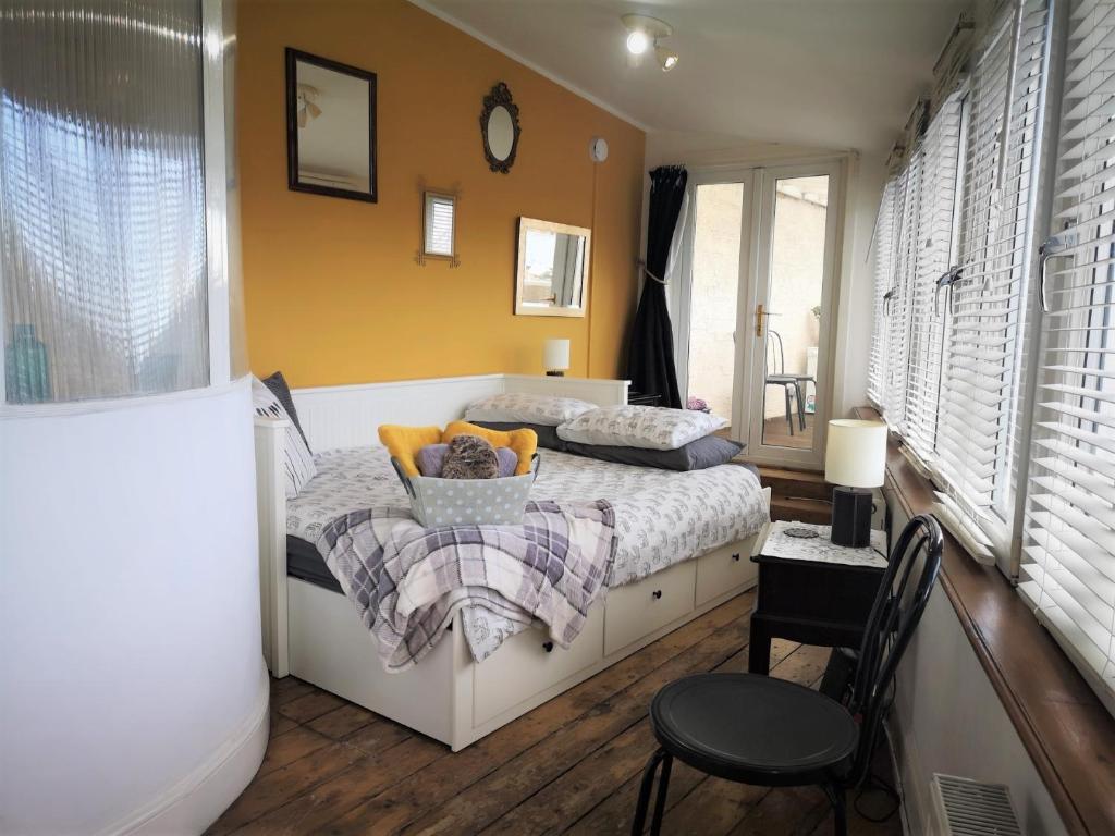 ein kleines Schlafzimmer mit einem Bett und einem Stuhl in der Unterkunft Heritage City - The Auld Pottery in Edinburgh