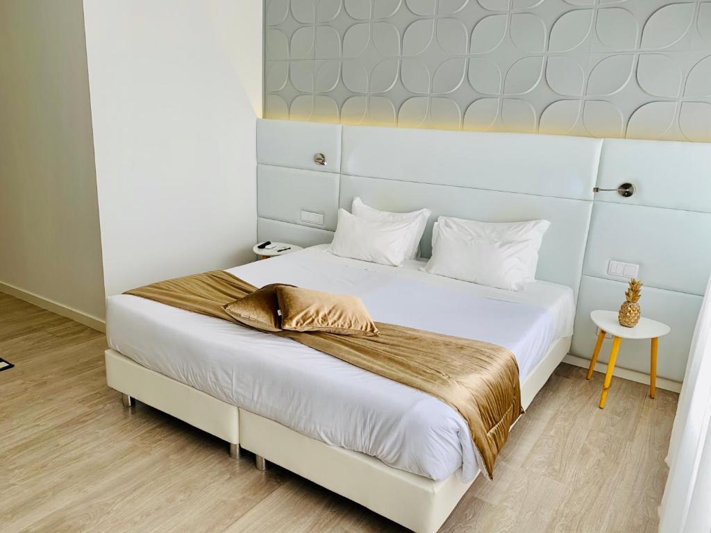 a bedroom with a large white bed with a wooden floor at Urban Apart - Azores in Ponta Delgada