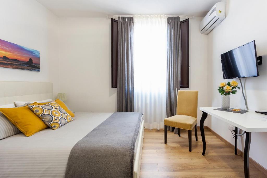 1 dormitorio con 1 cama y escritorio con ordenador en Centre Apartment Grotte Bianche en Catania