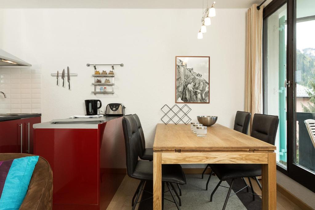 cocina y comedor con mesa de madera y sillas en Apartment Balme 3B, en Chamonix-Mont-Blanc