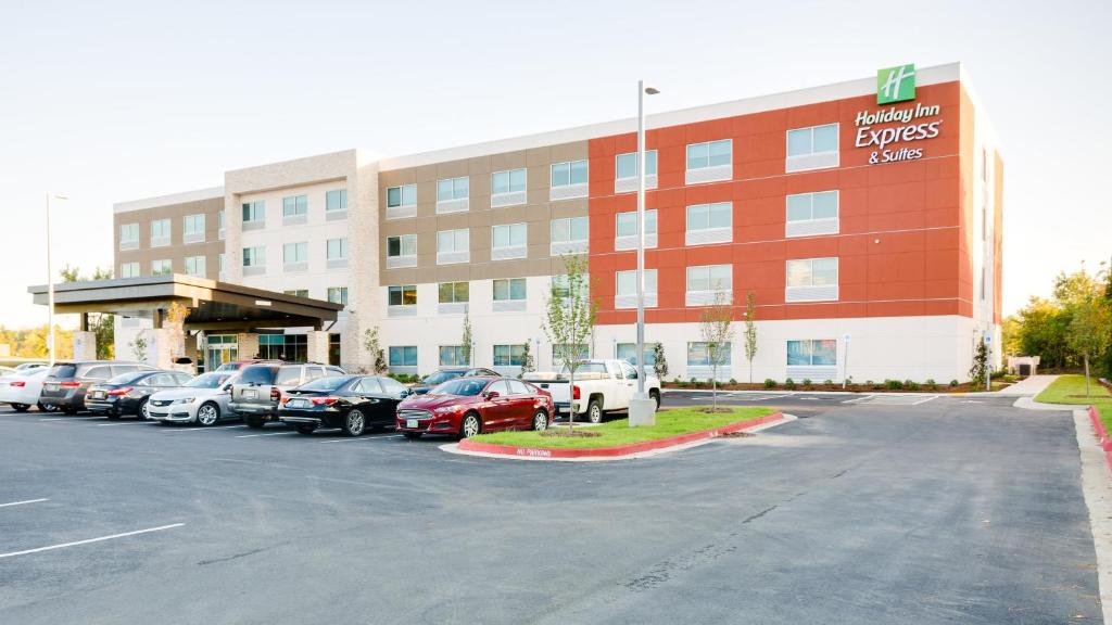 un estacionamiento con coches estacionados frente a un hotel en Holiday Inn Express & Suites Russellville, an IHG Hotel, en Russellville