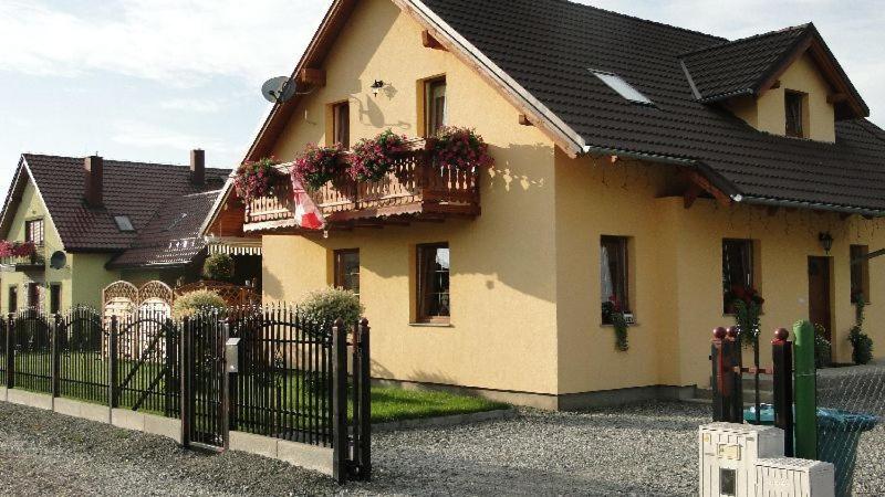 una casa con una valla delante de ella en Apartament Karpacz, en Mysłakowice