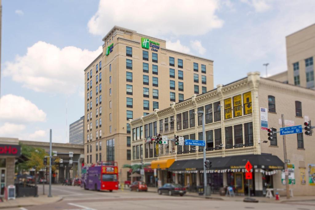 Holiday Inn Express & Suites Pittsburgh North Shore, an IHG Hotel في بيتسبرغ: مبنى طويل على شارع المدينة مع حافلة ذات طابقين