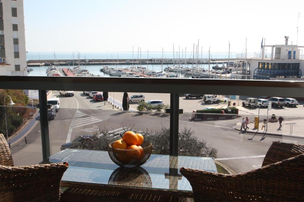 un tazón de naranjas sobre una mesa con vistas a un puerto en Rosa dels Vents, en L'Ampolla