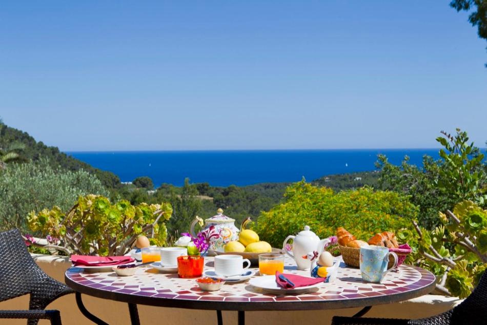 una mesa con comida y bebidas con vistas al océano en Agroturismo Can Talaias San CArlos, en Sant Carles de Peralta