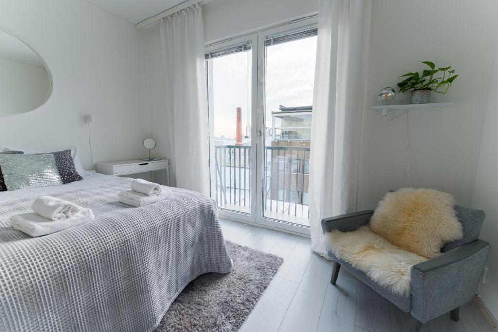 um quarto com uma cama, uma cadeira e uma janela em Compact high quality top floor studio in perfect location em Oulu